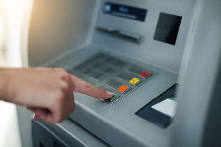 Woman using banking machine. Close upの写真素材