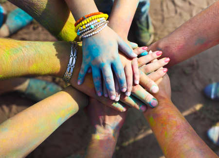 Friends putting their hands together in a sign of unity and teamwork. Holi colors festival. Friendship conceptの写真素材
