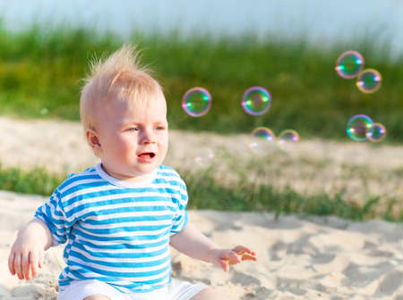 Baby on the beach playing with soap bubbles. Summerの写真素材