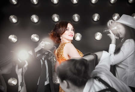 Superstar woman wearing golden shining dress posing to paparazzi