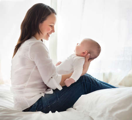 Portrait of a happy mother and child laughing and playing