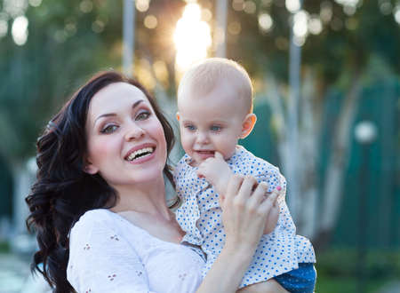 Portrait of a mother and her baby enjoy the summer sunsetの写真素材