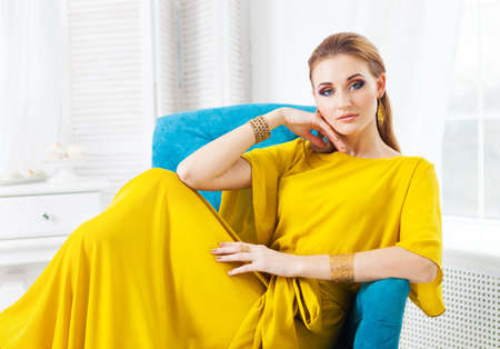 Portrait of young beautiful girl with make up wearing long yellow dressの写真素材