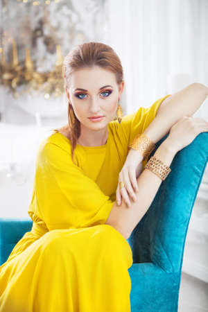 Portrait of young beautiful girl with make up wearing long yellow dressの写真素材