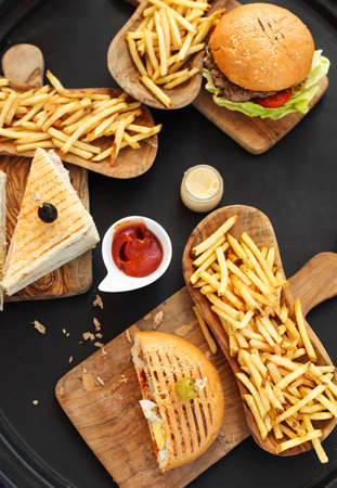 Closeup of burgers and french fries on dark backgroundの写真素材