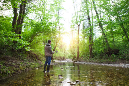 Fisherman with fly-fishing on mountain river. Spring timeの写真素材