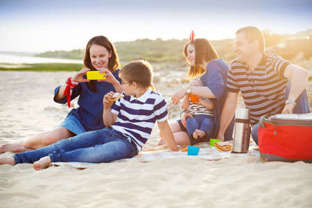 Family of five doing selfy at the picnic on the beach. Summer vacation conceptの写真素材