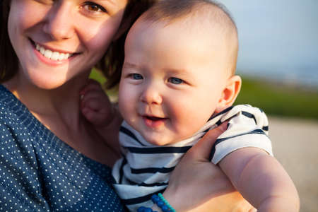 Portrait of happy teen sister and little baby brother on the beach