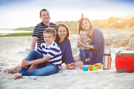 Family of five at the picnic on the beach. Summer vacation conceptの写真素材