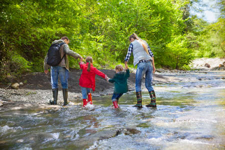 Happy young family with two little daughters on mountain trekの写真素材