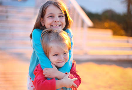 Sisters playing on the beach at the evening time. Concept of love and friendshipの写真素材