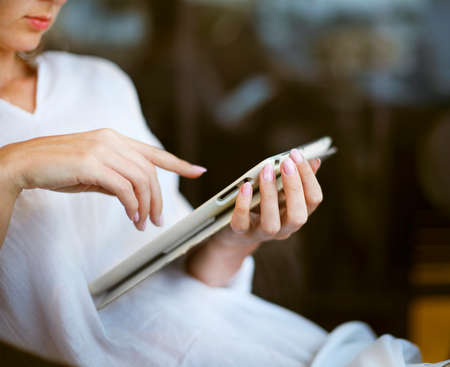Young woman having fun using a tablet computer outdoors. Close up