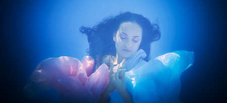 Underwater close up portrait of a woman in swimming poolの写真素材