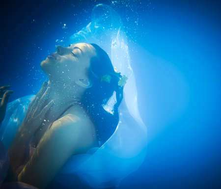Underwater close up portrait of a woman in swimming poolの写真素材