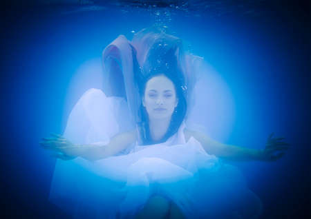 Underwater close up portrait of a woman in swimming poolの写真素材