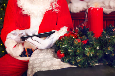 Close up hands of  Santa Claus using a tablet computerの写真素材
