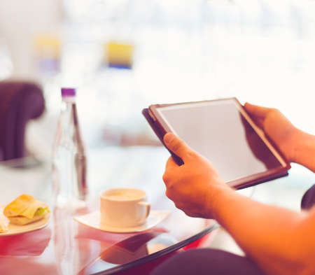 Man holding tablet computer in cafe. Toned photo