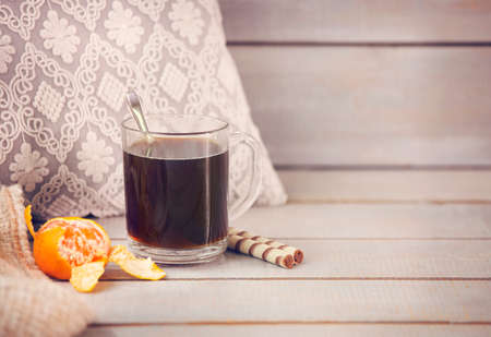 Black coffee and tangerine on light wooden backgroundの写真素材