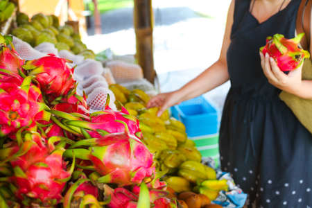 Woman choosing fruits in the open air fruit market in the village in Thailandの写真素材