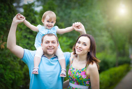 Happy young family with baby girl spending time outdoor in summer day