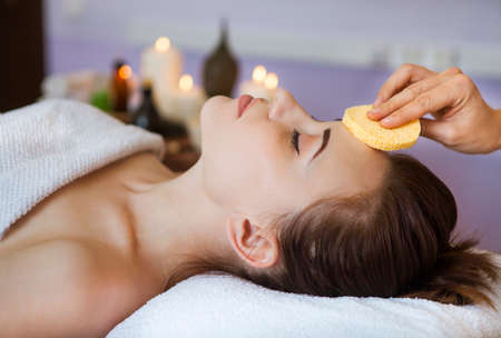 Relaxed woman with a deep cleansing nourishing face mask applied to her face. Spa treatmentの写真素材