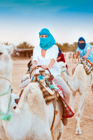 Young caucasian woman tourist riding on camel in Sahara desert. Tunisの写真素材