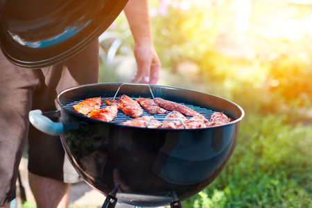 Man cooking fish fillets on the grill with flames in horizontal orientationの写真素材