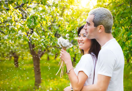 Happy smiling couple in love in bloomy spring gardenの写真素材