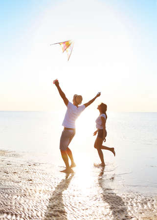Happy young couple with flying a kite on the beach. Holiday conceptの写真素材