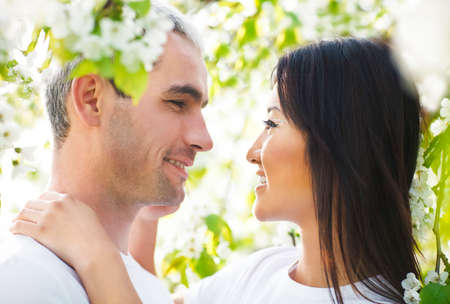 Happy smiling couple in love in bloomy spring gardenの写真素材