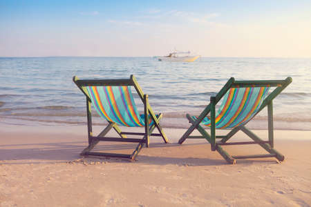 Two empty sun chairs on the beach of Koh Samet, Thailand