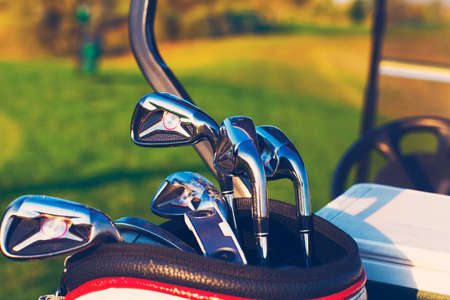Golf clubs drivers over green field background. Summer sunsetの写真素材
