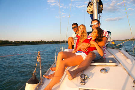 Smiling friends on yacht deck and greeting. Travel and vacation conceptの写真素材