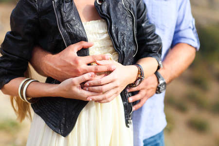 Close up hands of a young couple holding hands outdoorsの写真素材