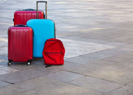 Luggage consisting of three large suitcases and travel backpack on the street. Holiday and travel conceptの写真素材