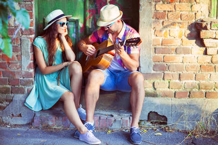 Romantic young couple playing Guitar outdoor. Love and travel conceptの写真素材