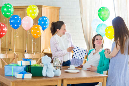 Portrait of pregnant woman with friends at a baby showerの写真素材