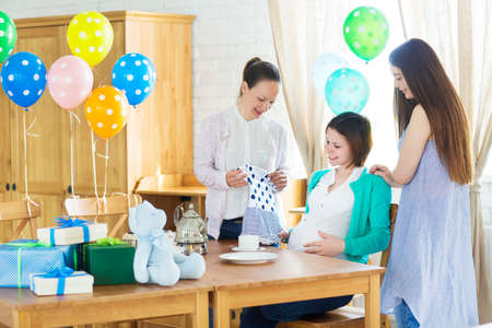 Portrait of pregnant woman with friends at a baby showerの写真素材