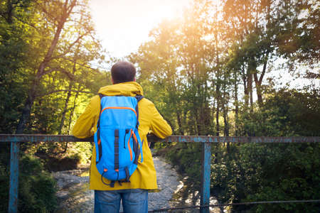 Tourist man on the old bridge over mountain riverの写真素材