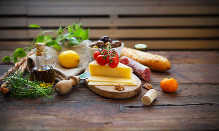 Italian food ingredients with olive oil on wooden background