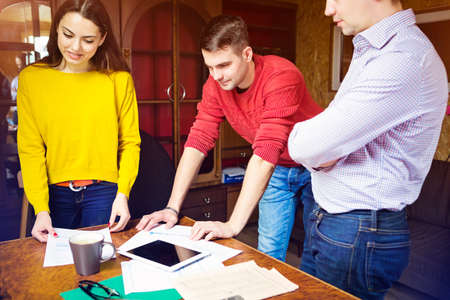 Business team at work with financial reports and a tablet computer