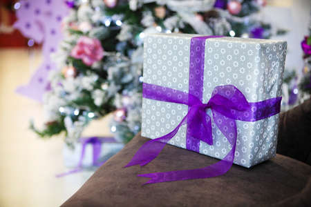 Christmas present by the Christmas tree with defocused lights