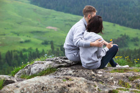 Young loving couple relaxing and hugging, she is smiling and leaning on his shoulder, relationships...