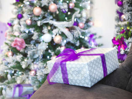 Christmas present by the Christmas tree with defocused lightsの写真素材