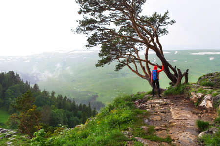 Hiking woman, climber or trail runner in mountains, inspirational landscape. Hiker with backpack looking at beautiful view. Travel, fitness and healthy lifestyle outdoors in summer nature.の写真素材