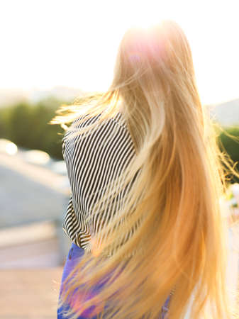 Outdoors portrait of beautiful young blond woman looking at camera.の写真素材