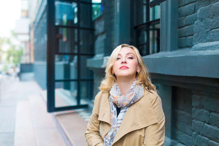 Middle age women goes through the city and smiles. Happiness concept.の写真素材