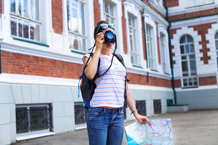 Cheerful woman making photo traveling abroad in summer, happy female siteseeing in a foreign city...