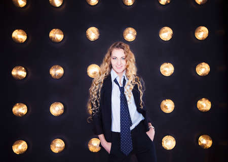 Blond happy woman wearing classical suit over golden shining background  