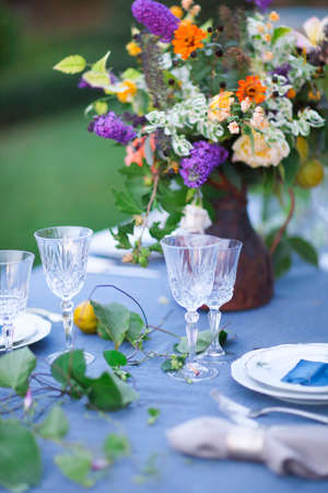 Bouquet of pink, violet and yellow flowers on a table set for dinner, close up の写真素材